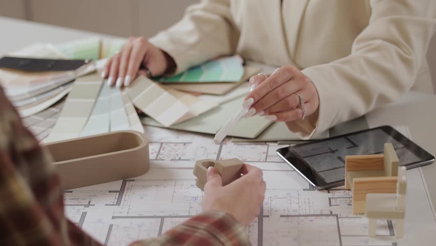 Collaborative interior design planning with color swatches and architectural models.