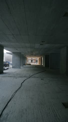 Sunset light inside a concrete structure of a modern building under construction with warm shadows and architectural lines.