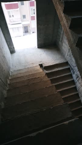 Concrete stairs in a modern building under construction, leading upward in natural light.