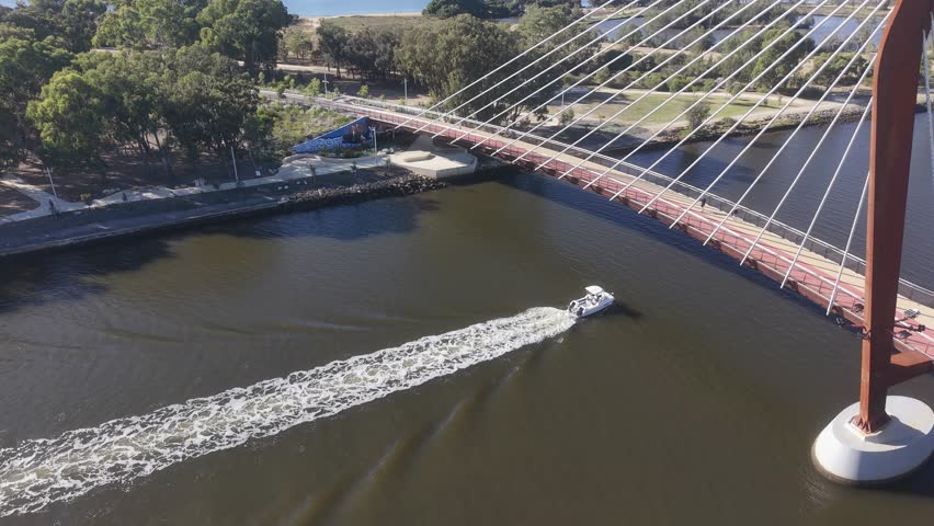 An aerial view captures a striking Boorloo pedestrian Bridge Over channels of the Swan River and Heirisson Island with the modern Perth cityscape, Western Australia.