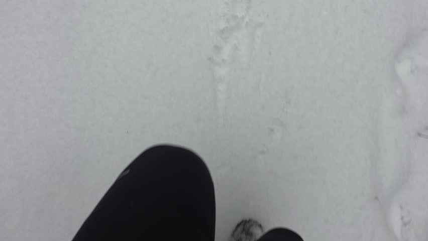 Point of view video showing a runner’s legs and feet while running on a trampled snowy trail. Footsteps move through packed snow, capturing the rhythm of winter running in a natural outdoor environment.