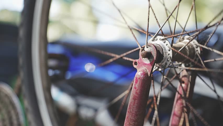 The spinning wheel of an old bicycle close-up. Either after a fall accident, or a bicycle workshop. High quality 4k footage. rusty spokes and an old bicycle tire in the workshop