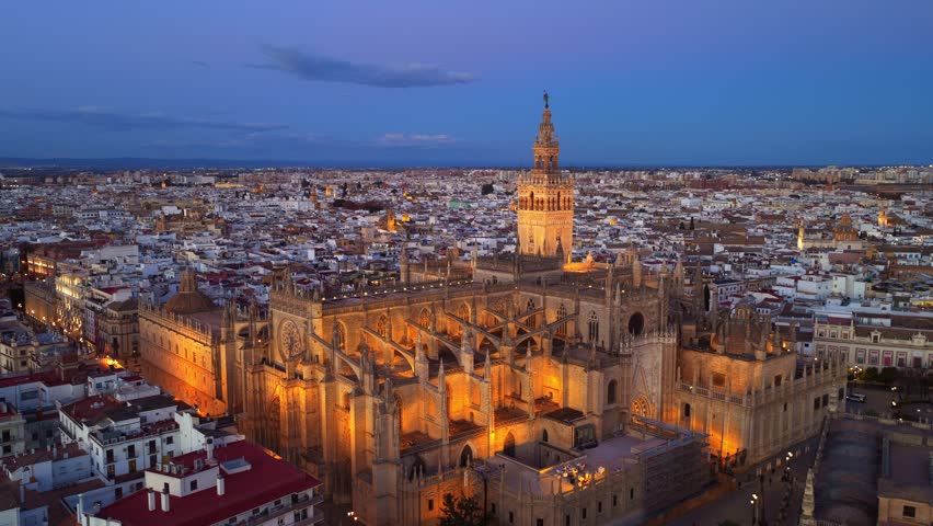 evening in Seville, aerial establishing shot of Seville gothic cathedral with famous Giralda bell tower. Travel in Seville, Spain. High quality 4k footage