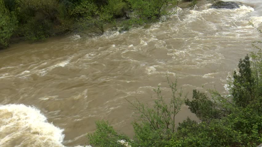 After days of relentless rain, the Cadagua River surges through Alonsotegi with an intensity rarely seen. Its waters, normally calm as they wind between the town’s bridges and wooded banks, now rush forward in a powerful torrent, churning in shades of brown and white. The swollen current crashes against rocks and river walls, carrying branches and debris as a reminder of the storm’s force. In the misty air, the roar of the river dominates the landscape, capturing a raw and dramatic moment in this Basque valley as nature briefly reclaims its strength