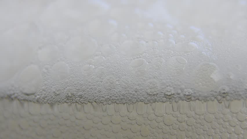 Beer Foam rising and filling the glass - HD, 1080i macro shot of beer foam