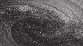 Detailed close-up of dark titanium paint swirling continuously into a deep vortex shape while highlighting specialized sandy texture and radiant glitter particles on the surface - Powered by Shutterstock - Get 15% off with code: PIKWIZARD15