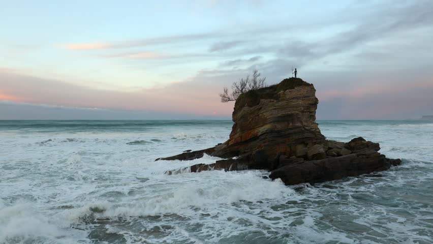 The turbulent ocean is flooding the coastal rock on the beautiful Kamelowa Beach (Playa del Camello) in Santander. The Cantabria region in Spain.