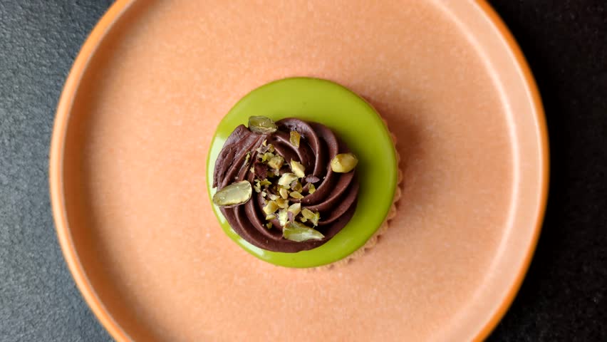 Pistachio cake or tart topped with green mousse with nuts and fruit filling. Pistachio pie