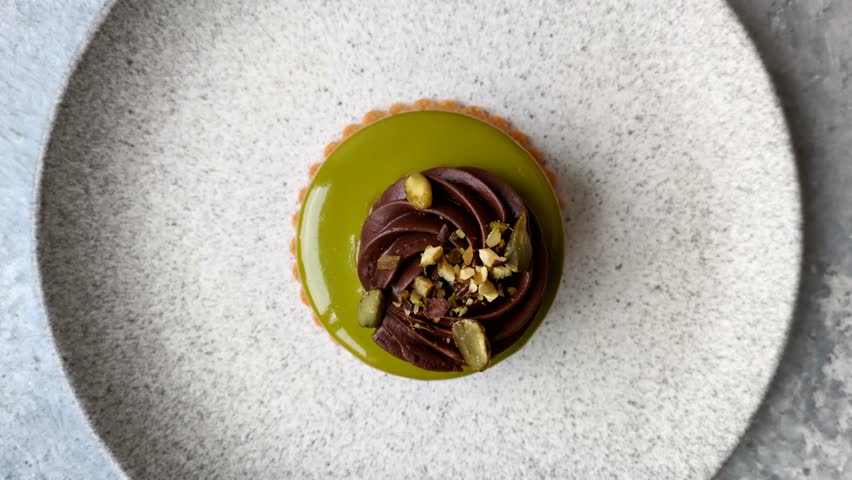 Pistachio cake or tart topped with green mousse with nuts and fruit filling. Pistachio pie