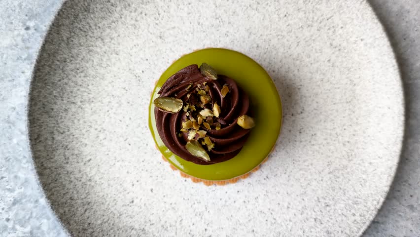 Pistachio cake or tart topped with green mousse with nuts and fruit filling. Pistachio pie