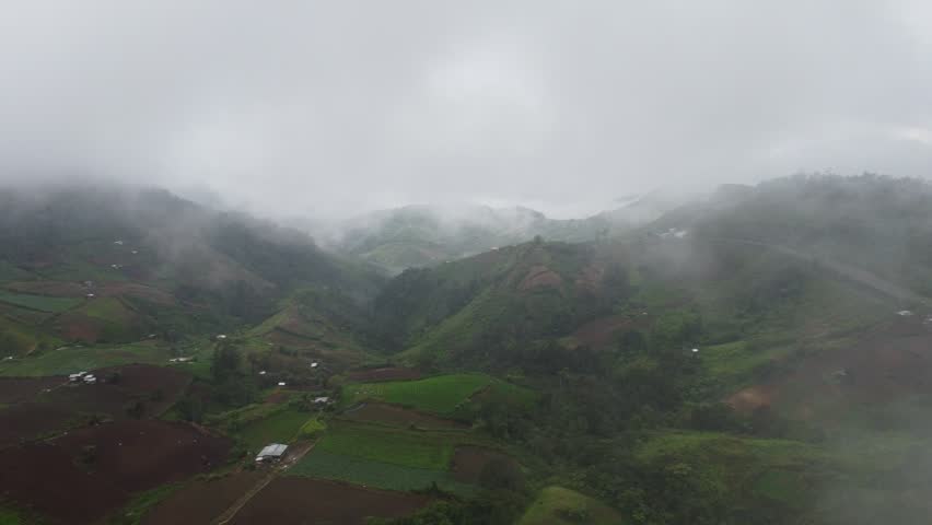 Drone shot of panoramic mountain landscape with sea of clouds during peaceful sunrise.