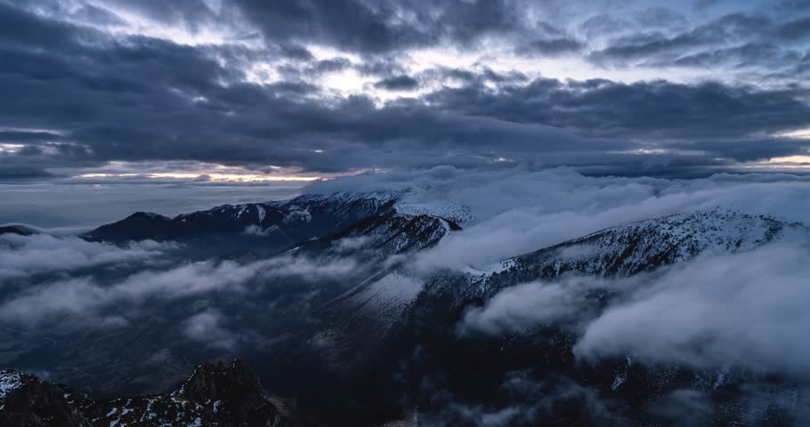 Dramatic Foggy Clouds Moving Over Winter Alpine Mountains at Cloudy Sunset, Timelapse