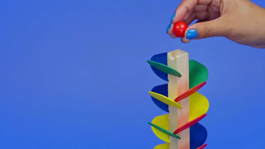 Girl Putting a Ball Down a Colorful Wooden Ball Maze, Child Playing with Educational Toy, Early Learning and Motor Skills Development, Montessori Inspired Playtime, Hands On Activity for Kids, Cognitive Growth and Problem Solving Concept, Childhood Education Scene, 4K Ultra HD Video