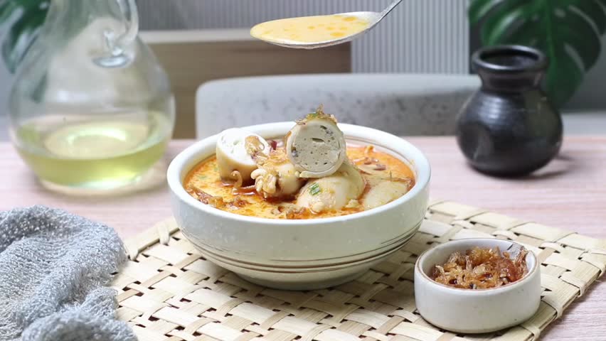 Indonesian gulai cumi bunting, gulai cumi isi tahu, squid stuffed with tofu simmered in aromatic coconut milk curry, spicy traditional Indonesian food, appetizing close-up