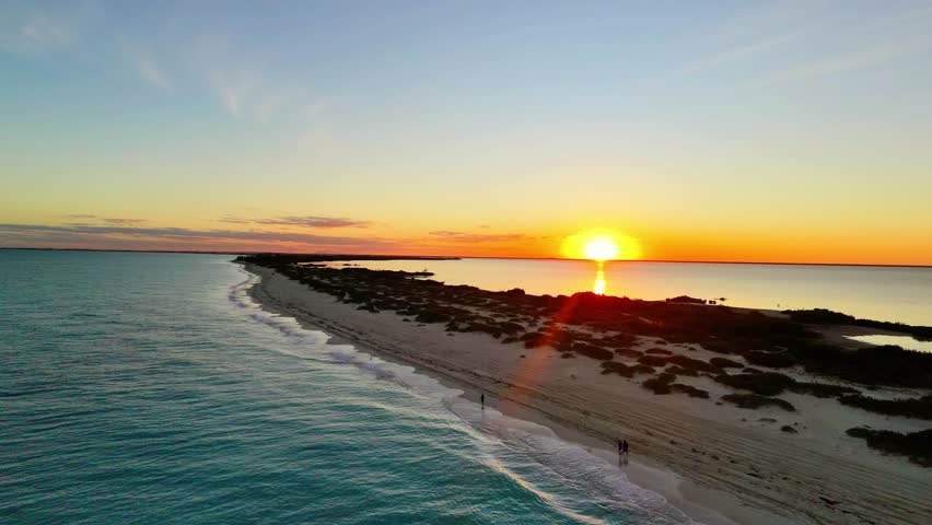Cinematic 4K aerial drone view of the untouched white sand beaches and turquoise waters of Isla Blanca peninsula in Cancun during the first sunset of the new year