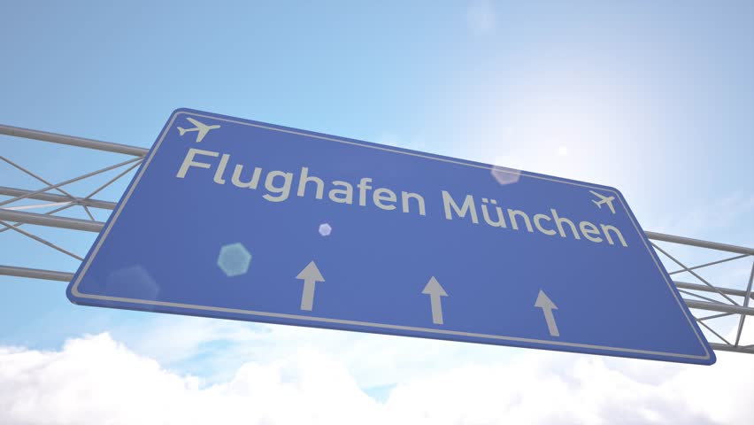 Highway marker pointing to Munich Airport with aircraft heading for touchdown, arriving to Munich, Germany.