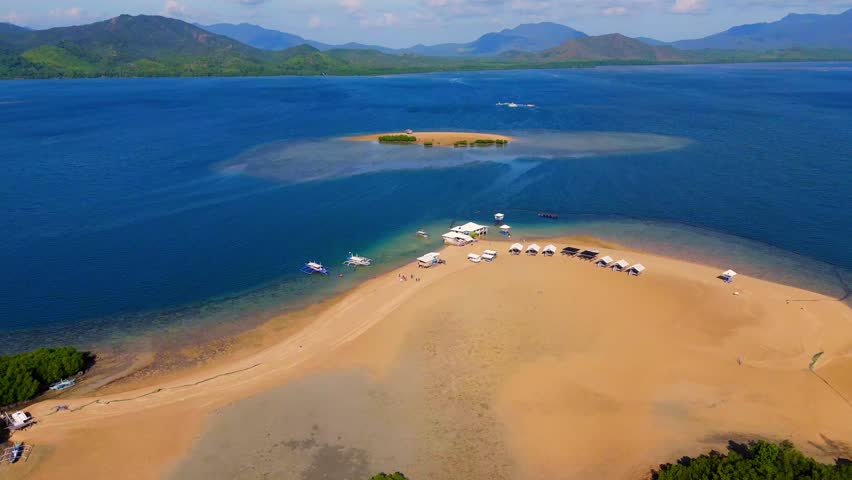 Cinematic drone footage revealing the lush mangroves and white sandy shores of Luli Island, a popular island-hopping destination in Palawan The Philippines 