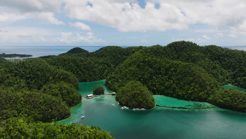 Turquoise water weaves between small green islets creating a scenic lagoon landscape. Sugba Blue Lagoon, Siargao, Philippines.