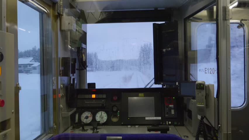 Interior view of train cabin looking out on snowy winter landscape at dusk