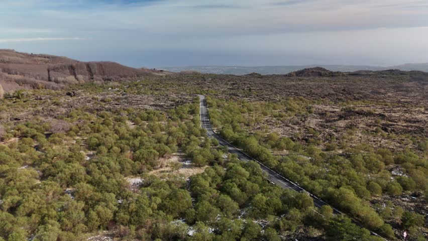 Scenic aerial view of a winding road through lush green mountain landscape