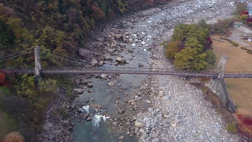 Flyover historic wooden Momosuke suspension bridge on Kiso River, Japan