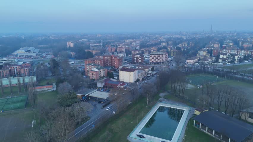 Aerial view along Viale Po shows residential neighborhoods of Cremona with the Torrazzo di Cremona and the Duomo di Cremona rising on the skyline in Lombardy, northern Italy.