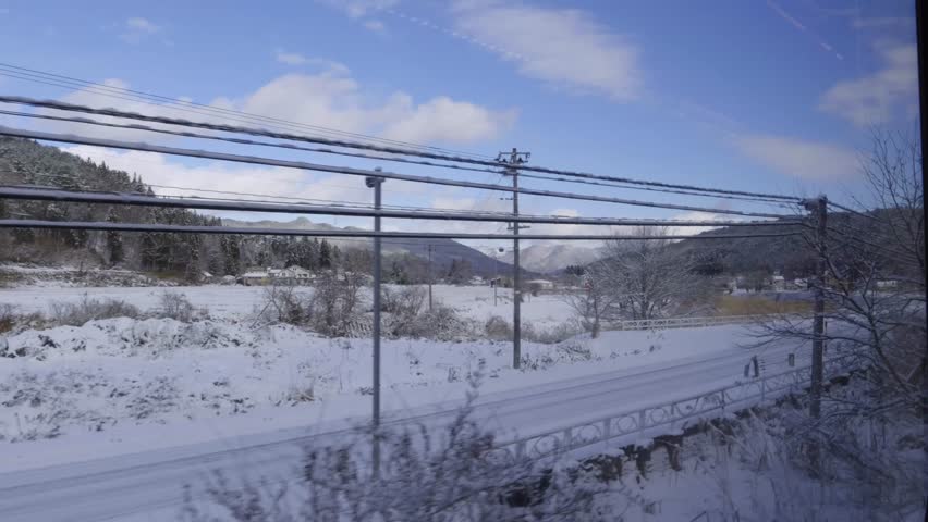 Perfect snowy winter rural landscape passing by from train window in slow motion
