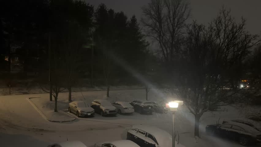 Nighttime Snowy Parking Lot with Passing Bus.