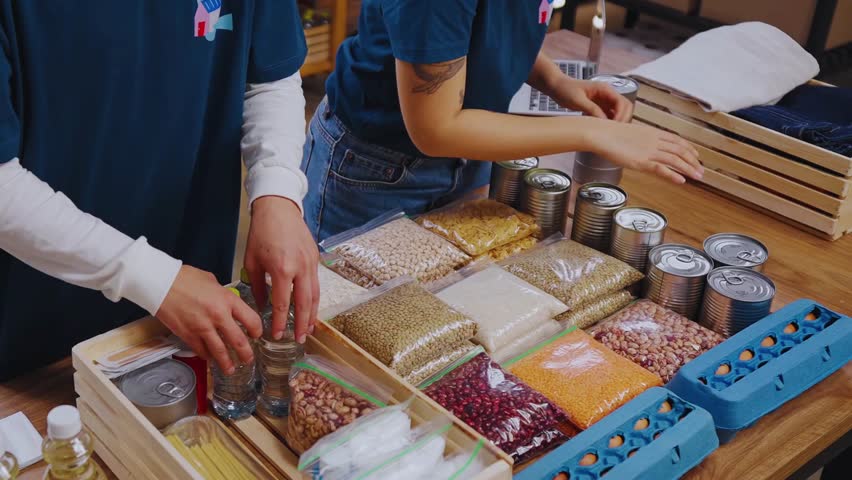 People sampling various food products from wooden crates on a table