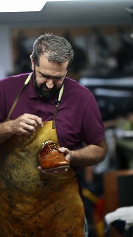 Dedicated Shoemaker Carefully Inspects and Polishes a Handcrafted Brown Leather Shoe in His Workshop