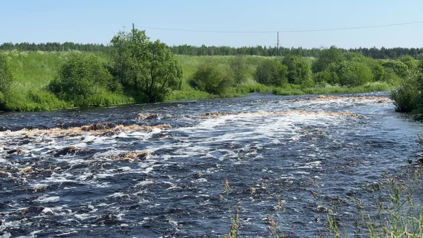 A wide, rushing waterfall with small cascade, creating foam, capturing the raw power of nature.