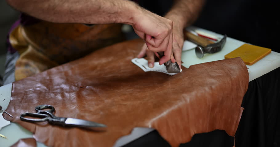 Skilled Artisan's Hands Meticulously Cutting Leather for Traditional Shoemaking and Crafting