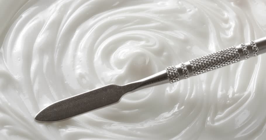 Smear of moisturizing cream made with a cosmetic spatula, close-up footage, cream texture.