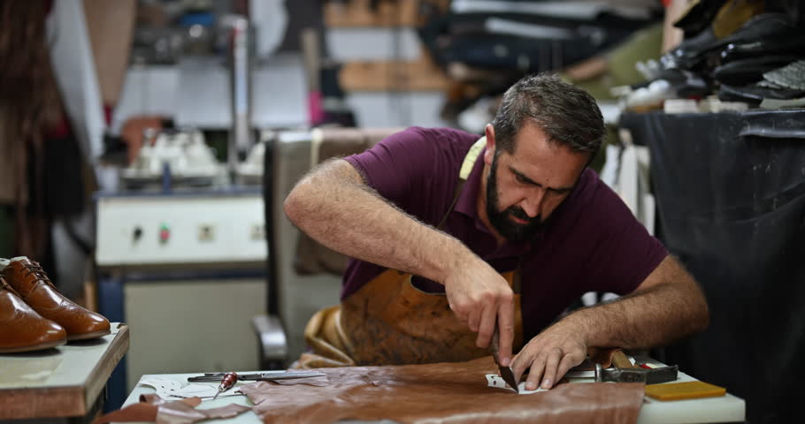 Skilled Craftsman Cutting Brown Leather with Precision to Create Bespoke Handmade Shoes