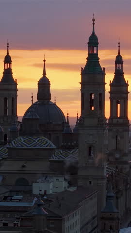 Aerial Vertical View Capturing Sunset Glow Illuminating Cathedral Domes And Tranquil River Reflections. Zaragoza. Spain 