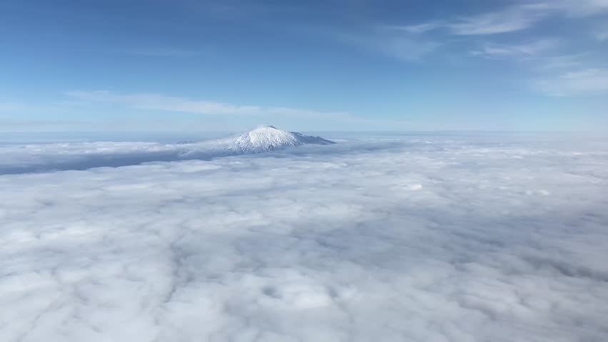 A sea of clouds embraces the snowy Etna Vulcan, in Sicily, Italy