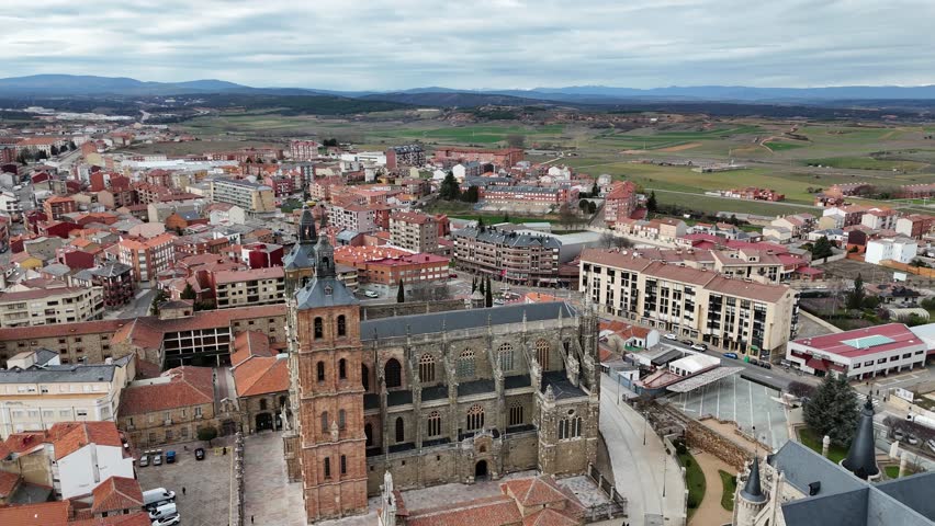 Vertical drone view of a classic European cathedral and nearby stone palace.
