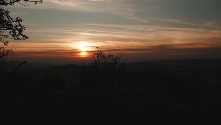 warm evening sky settling quietly over layered hills and treetops