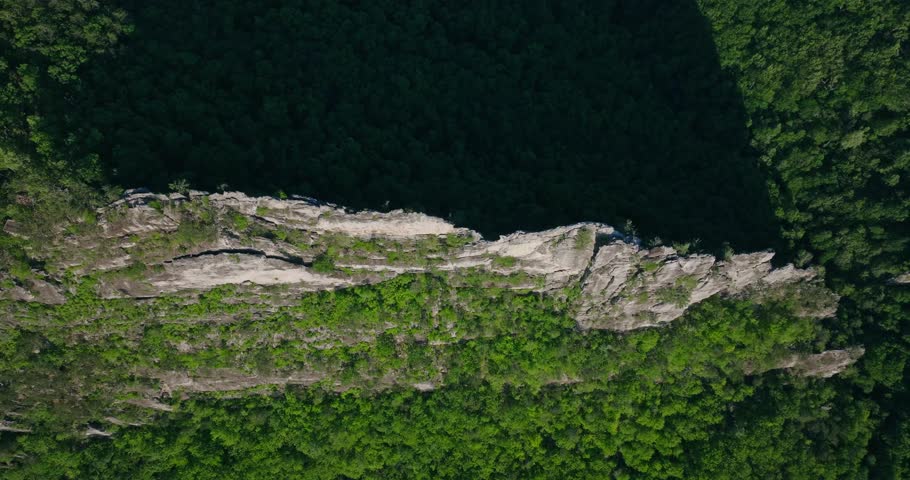 Aerial ridge layered rock formations casting long shadows, Seneca Rocks above lush Appalachian forest