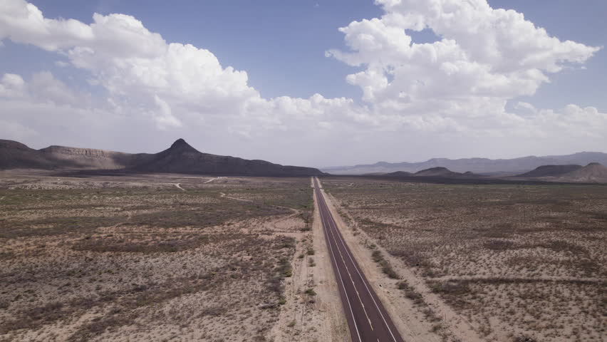 A desert landscape aerial of an empty stretch of highway in the Big Bend region of west Texas