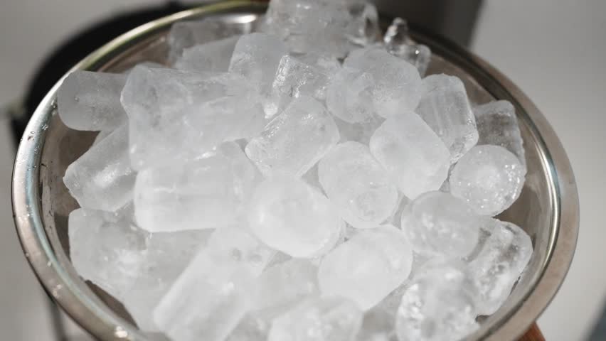Close up of frozen ice cubes filling a metal bowl