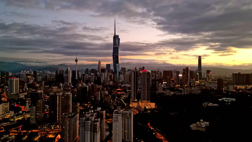 Aerial view of the Kuala Lumpur skyline with its tall buildings under a dramatic sky at dusk, Kuala Lumpur, Federal Territory of Kuala Lumpur, Malaysia.