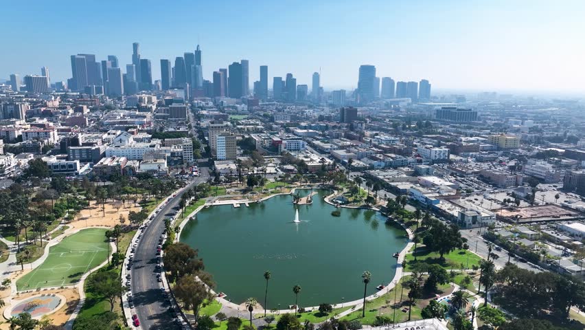 Aerial view of MacArthur Park, where the green of the park contrasts with the city skyline in the background, Los Angeles, California, United States.