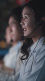 Vertical Screen : Asia young call center team or customer support service executive use computer and microphone headset working technical support in late night office. Telemarketing or sales job. - Powered by Shutterstock - Get 15% off with code: PIKWIZARD15