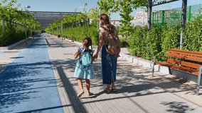 Mother taking her little girl to school in the morning. Back to school concept with a child and parent walking hand in hand in a park - Powered by Shutterstock - Get 15% off with code: PIKWIZARD15
