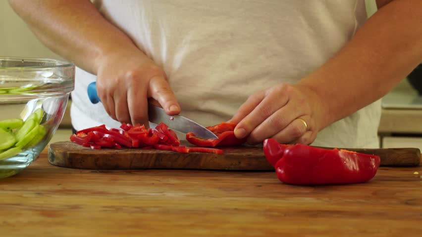 Woman cutting red pepper for salad