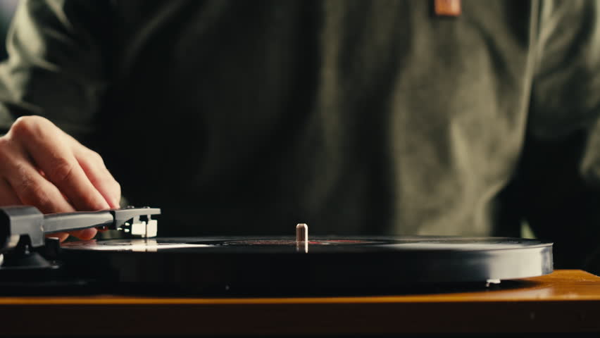Retro Vinyl record player playing music, needle close-up macro shot of vintage LP disc old phonograph spinning. Retro music player at home.