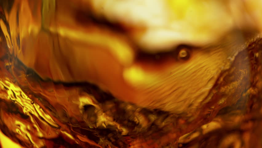 Super Slow Motion Shot of Waving Golden Alcohol Liquid Background at 1000fps.
