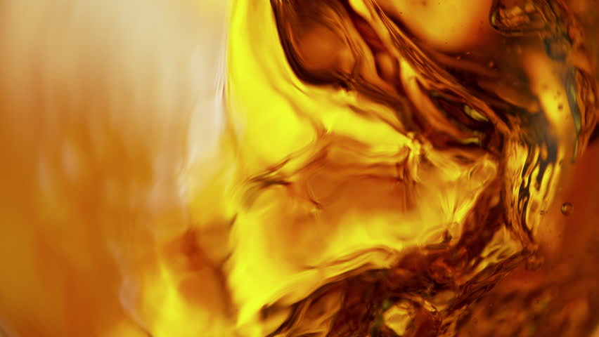 Super Slow Motion Shot of Waving Golden Alcohol Liquid Background at 1000fps.