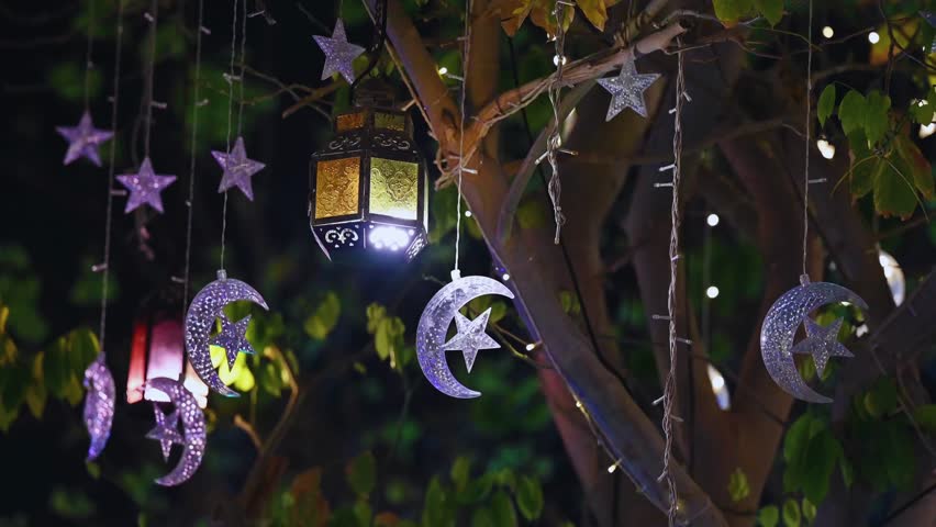 Enchanted tree with glowing lantern stars and moons dangling under deep night sky